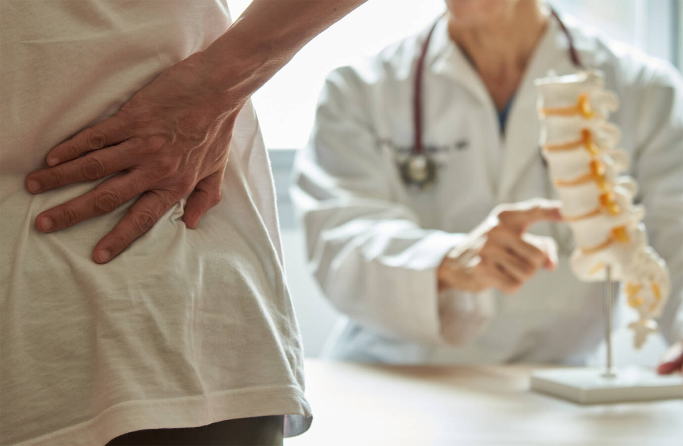 Ein Doktor erklärt einem Patienten den Grund für seine Rückenschmerzen